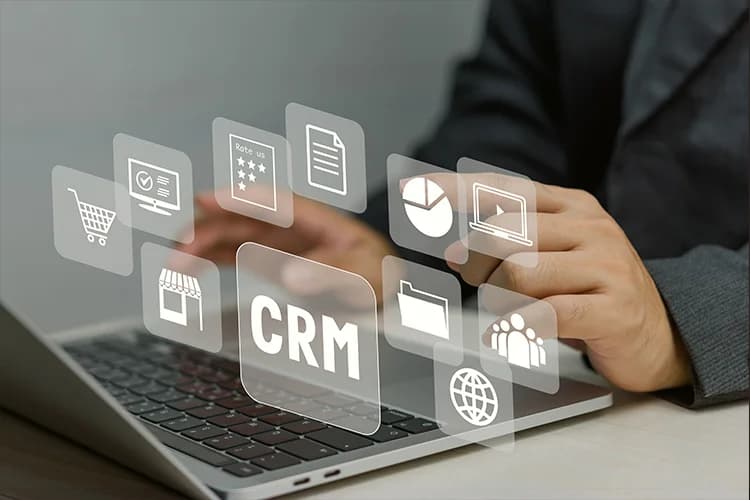 Person using laptop with digital CRM icons, representing key features and highlights of CRM software for small businesses.