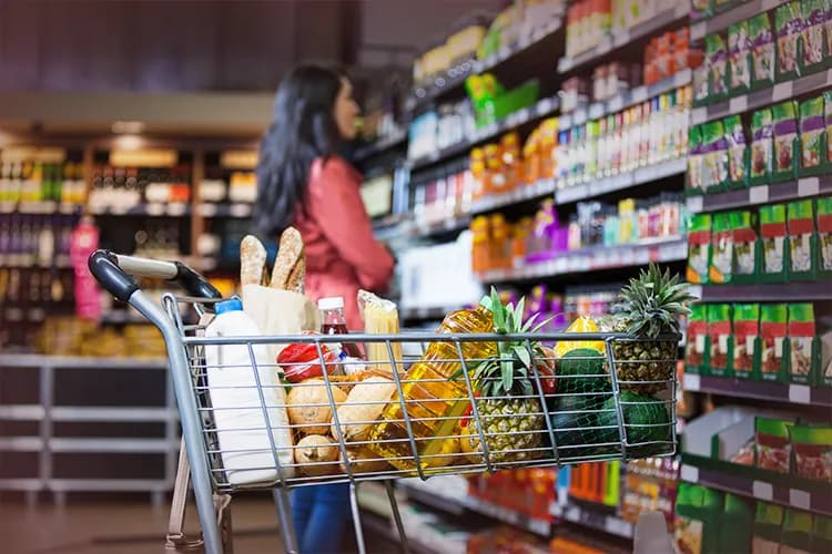 Shopping cart filled with groceries in a supermarket, representing all-in-one vendor management and retail software for retailers. 