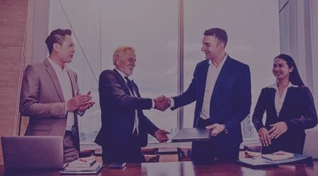 Close-up of business professionals shaking hands, symbolizing commitment and reliability in client partnerships.