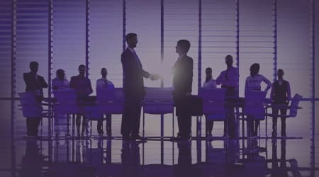 Two business professionals shaking hands over a city skyline, symbolizing trust, integrity, and reliability in partnerships and collaborations.